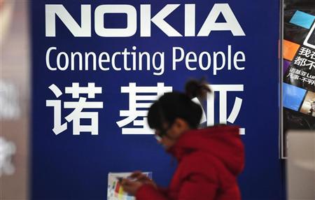 A woman walks past a Nokia advertisement board at a home appliances store in Shenyang