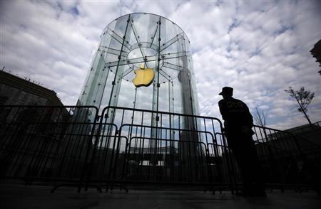 A security guard stands next to an Apple retail store during the release of the iPhone 5 in Shanghai
