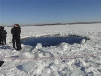 Russian police work near an ice hole at lake Chebarkul, said by the Interior Ministry department for Chelyabinsk to be the point of impact of a meteor