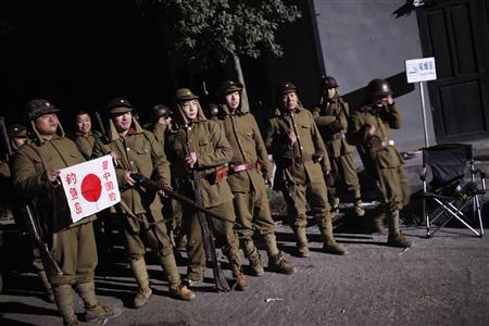 Actors in Japanese military uniforms take pictures during filming of World War Two movie in Hengdian Film City