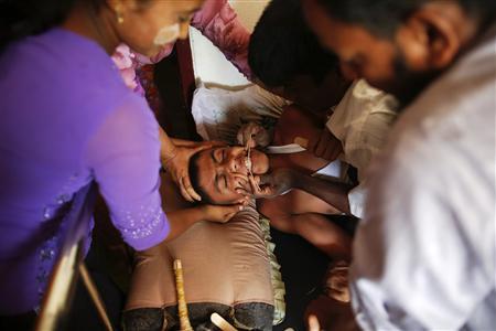 Wadulae, a 16-year-old Rohingya Muslim boy with severe symptoms of rabies, is comforted by family members at a local clinic at a camp for people displaced by violence near Sittwe April 29, 2013. REUTERS/Damir Sagolj