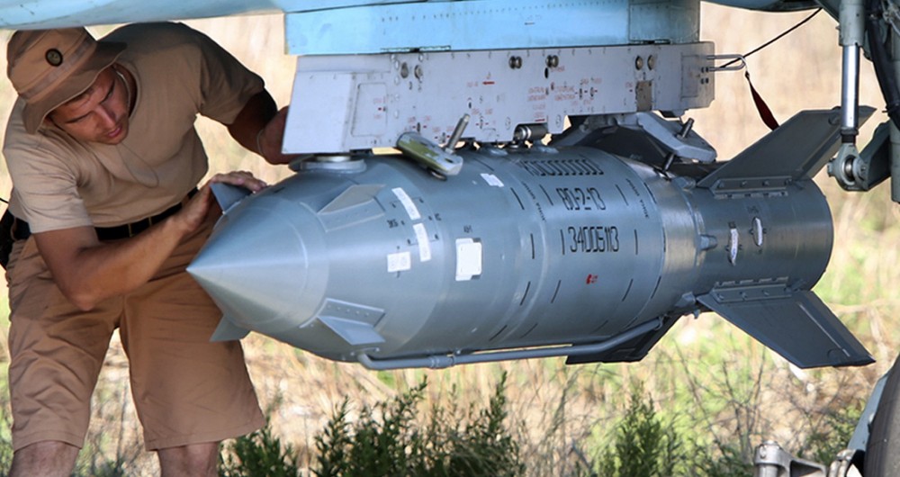 In this photo taken on Saturday, Oct. 3, 2015, Russian military support crew attach a satellite guided bomb to SU-34 jet fighter at Hmeimim airbase in Syria. Russia has insisted that the airstrikes that began Wednesday are targeting the Islamic State group and al-Qaida's Syrian affiliates, but at least some of the strikes appear to have hit Western-backed rebel factions. (AP Photo/Alexander Kots, Komsomolskaya Pravda, Photo via AP)
